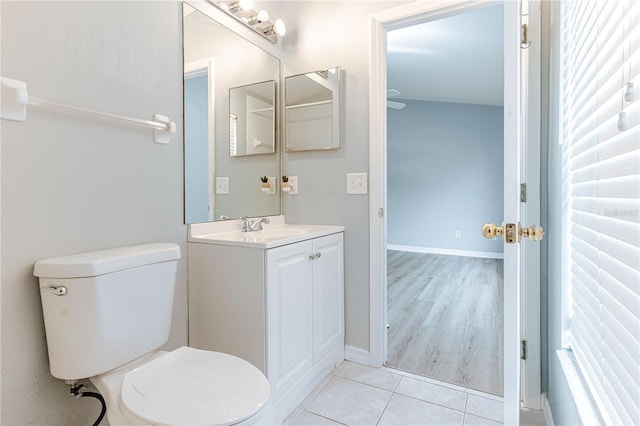 bathroom featuring toilet, tile patterned flooring, vanity, and baseboards
