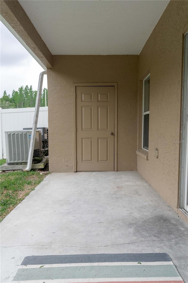 view of patio with cooling unit and fence