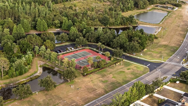 aerial overview of property's location with a nearby body of water and a heavily wooded area