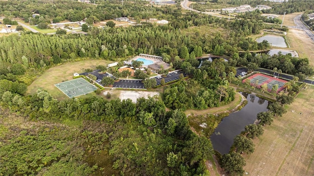 view of property location with a nearby body of water and a heavily wooded area