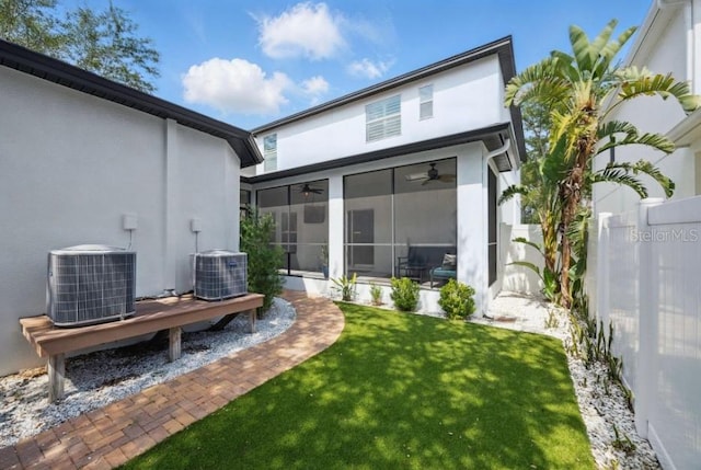 rear view of property featuring central air condition unit, a ceiling fan, stucco siding, and a sunroom