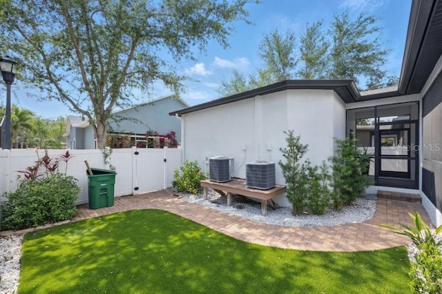 view of yard featuring central air condition unit and a gate