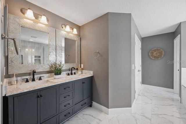 full bathroom with baseboards, marble look tile flooring, double vanity, and tasteful backsplash
