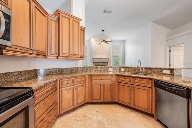 12421 Seabrook Dr, Tampa, FL 33626 - kitchen with appliances with stainless steel finishes, a sink, a ceiling fan, brown cabinetry, and stone counters