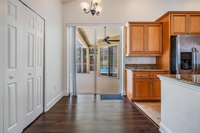 12421 Seabrook Dr, Tampa, FL 33626 - kitchen featuring stainless steel fridge with ice dispenser, brown cabinetry, dark wood finished floors, and dark stone countertops