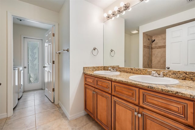 12421 Seabrook Dr, Tampa, FL 33626 - full bath featuring washing machine and dryer, tile patterned flooring, double vanity, baseboards, and tiled shower