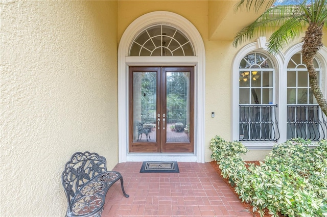 property entrance with french doors and stucco siding