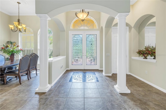 entryway featuring french doors, a chandelier, and baseboards