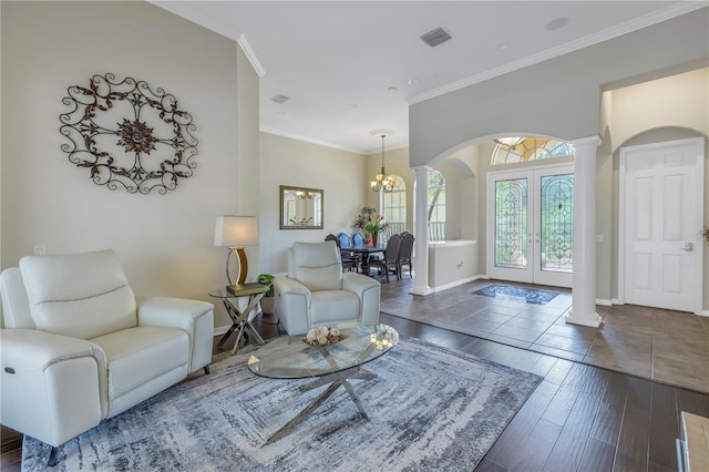 living room with decorative columns, arched walkways, french doors, baseboards, and ornamental molding