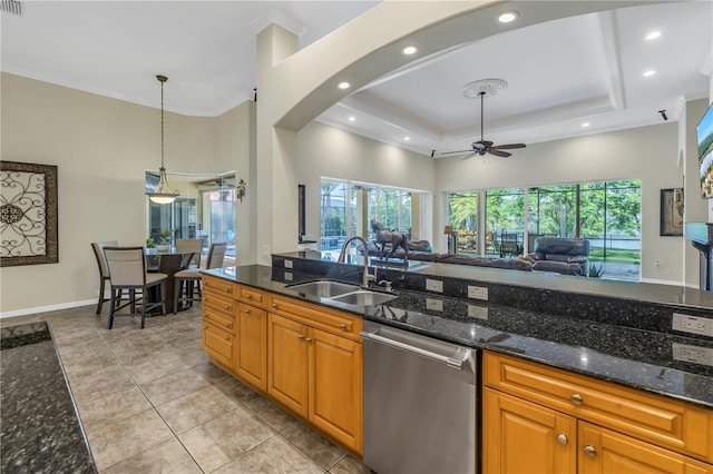 kitchen featuring dishwasher, a sink, open floor plan, ceiling fan, and healthy amount of natural light
