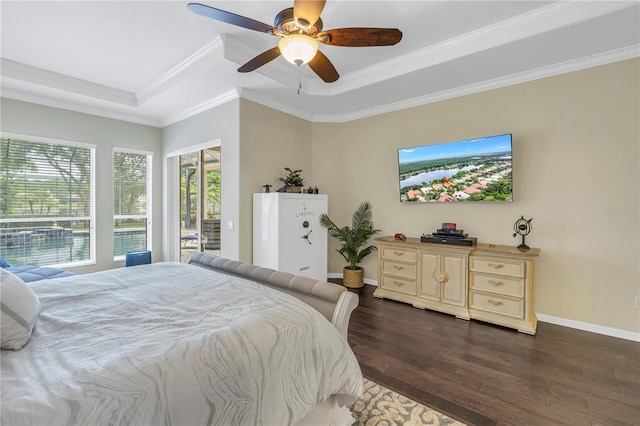 bedroom featuring a raised ceiling, dark wood-style flooring, ornamental molding, a ceiling fan, and baseboards