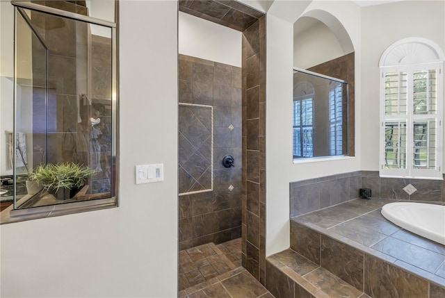 bathroom with a tile shower and a garden tub