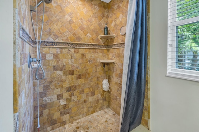 full bath featuring a tile shower and plenty of natural light