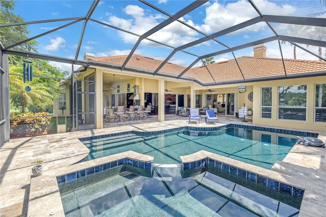 view of pool with ceiling fan, a patio, a pool with connected hot tub, outdoor dining space, and glass enclosure