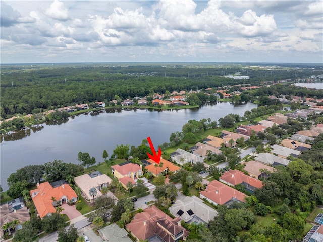 aerial view of residential area with a nearby body of water and a heavily wooded area
