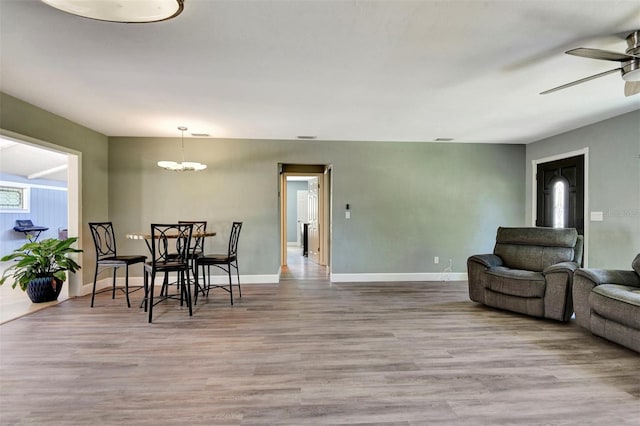 781 Little Pine Dr, South Daytona, FL 32119 - dining room featuring wood finished floors, ceiling fan, a chandelier, and baseboards