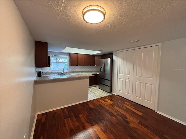 14446 Reuter Strasse Cir Unit 3, Tampa, FL 33613 - kitchen with stainless steel fridge with ice dispenser, dark brown cabinets, light wood-style flooring, a textured ceiling, and light countertops