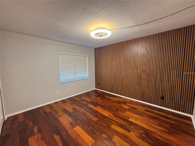 14446 Reuter Strasse Cir Unit 3, Tampa, FL 33613 - unfurnished room with wood finished floors, baseboards, a textured ceiling, and wood walls