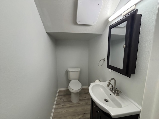 14446 Reuter Strasse Cir Unit 3, Tampa, FL 33613 - bathroom with vanity, wood finished floors, toilet, and baseboards