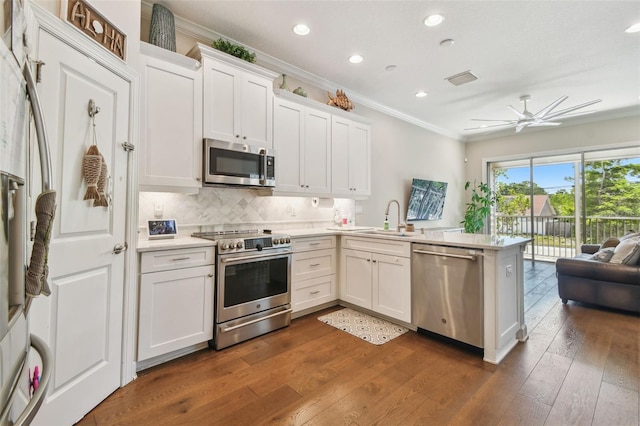 6140 Marina Cove Way S, Saint Petersburg, FL 33712 - kitchen featuring appliances with stainless steel finishes, a peninsula, a sink, crown molding, and light countertops