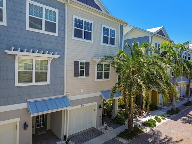 6140 Marina Cove Way S, Saint Petersburg, FL 33712 - view of side of property featuring an attached garage, a standing seam roof, driveway, and metal roof