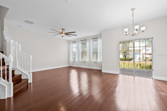unfurnished living room with a ceiling fan, a chandelier, baseboards, and healthy amount of natural light