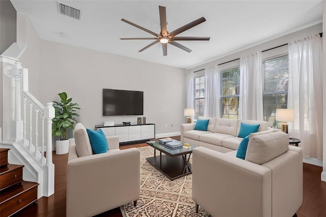 living area featuring a ceiling fan, wood finished floors, stairway, and baseboards