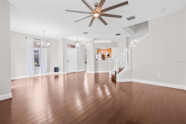 unfurnished living room with a ceiling fan, a chandelier, stairs, wood finished floors, and baseboards