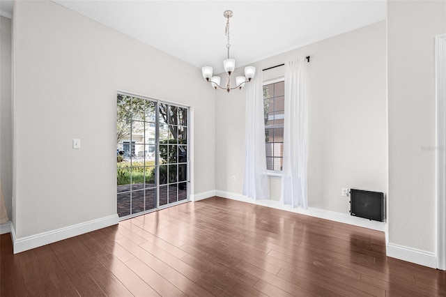 unfurnished dining area featuring a chandelier, baseboards, and dark wood-style floors