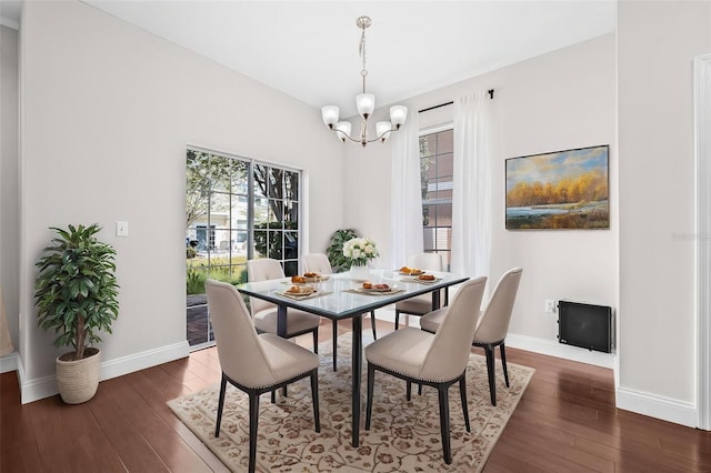 dining area with a chandelier, dark wood finished floors, and baseboards