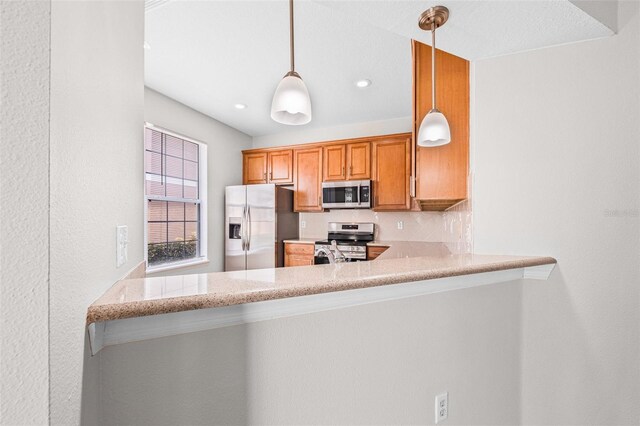 kitchen with stainless steel appliances, a peninsula, pendant lighting, recessed lighting, and light stone counters