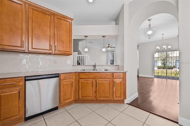 kitchen with stainless steel dishwasher, a sink, brown cabinetry, decorative backsplash, and ceiling fan