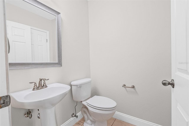 bathroom with baseboards, toilet, and tile patterned floors