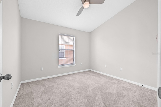 carpeted spare room with ceiling fan, baseboards, and vaulted ceiling