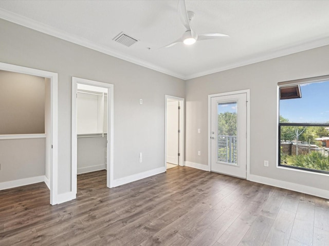 946 Highland Ave Unit 24, Dunedin, FL 34698 - unfurnished bedroom with ornamental molding, wood finished floors, a spacious closet, and baseboards