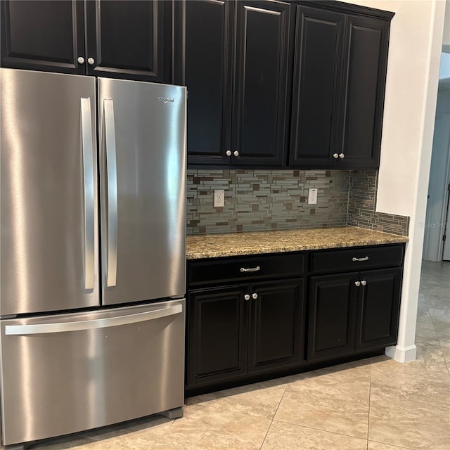 12055 Cardinal Flower Dr, Riverview, FL 33579 - kitchen with freestanding refrigerator, dark cabinets, tasteful backsplash, and light stone countertops