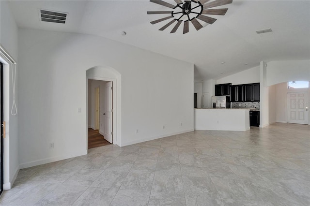 12055 Cardinal Flower Dr, Riverview, FL 33579 - unfurnished living room with vaulted ceiling, a ceiling fan, arched walkways, and baseboards