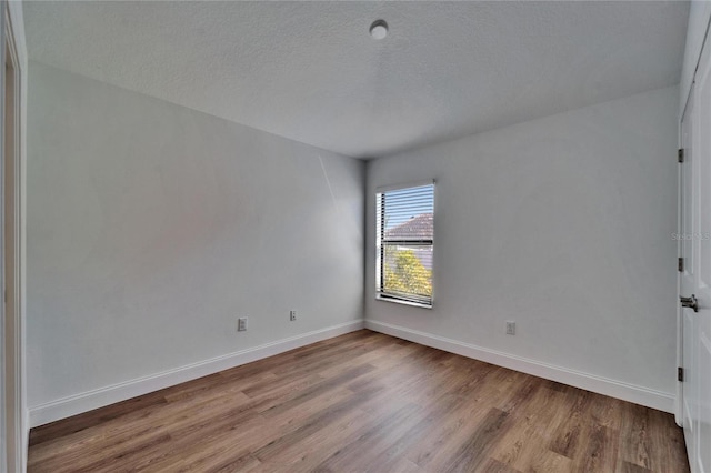 12055 Cardinal Flower Dr, Riverview, FL 33579 - unfurnished room featuring wood finished floors, baseboards, and a textured ceiling