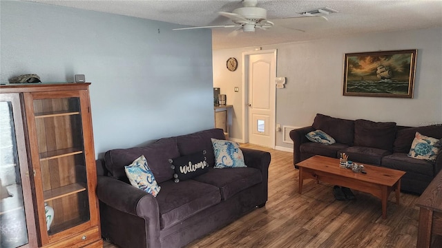 living room with wood finished floors, ceiling fan, and a textured ceiling