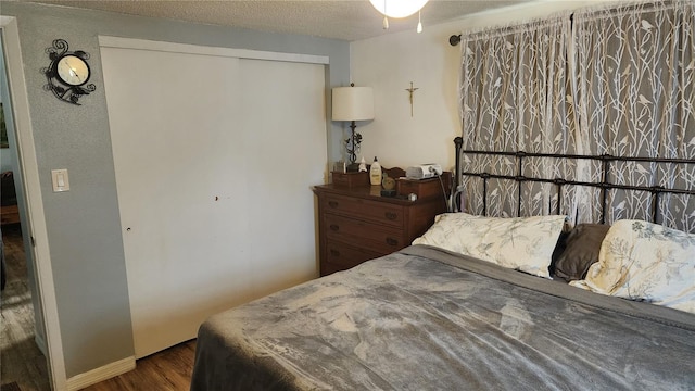 bedroom featuring wood finished floors, a textured ceiling, and a closet