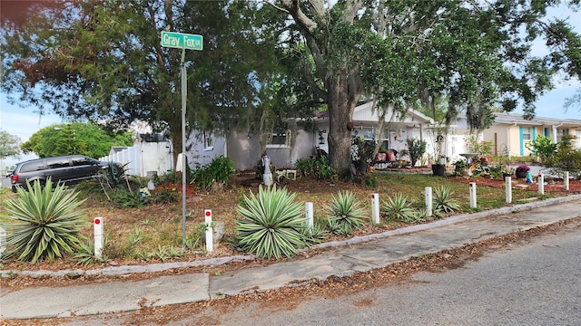 view of property hidden behind natural elements with fence