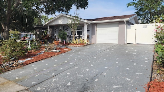 ranch-style house featuring a porch, a garage, concrete driveway, stucco siding, and a gate