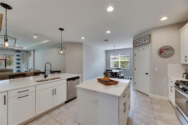 kitchen featuring stainless steel dishwasher, range with gas cooktop, a sink, a kitchen island, and recessed lighting