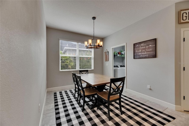 dining space with independent washer and dryer, a chandelier, light tile patterned floors, baseboards, and a textured ceiling