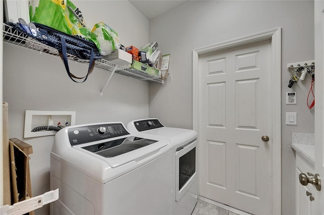 laundry area featuring washer and clothes dryer and light tile patterned flooring