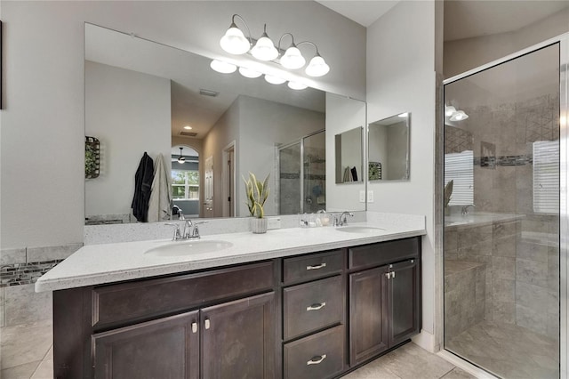bathroom with a shower stall, double vanity, and tile patterned floors