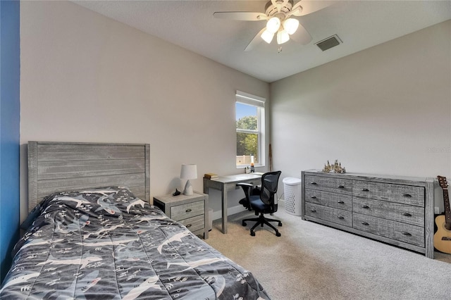 carpeted bedroom featuring a ceiling fan and an office area