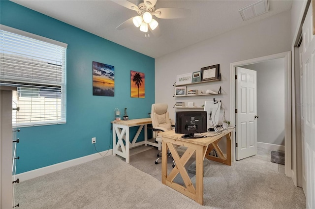 carpeted home office with ceiling fan and baseboards