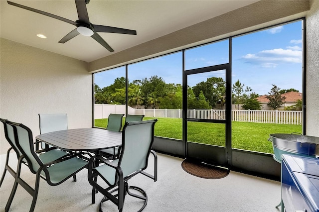 sunroom with ceiling fan and outdoor dining area
