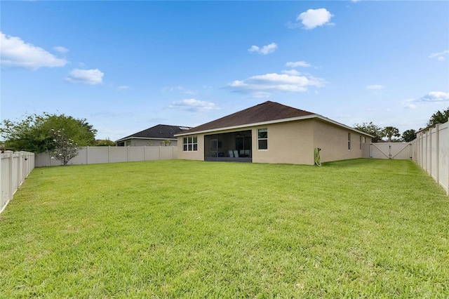 back of house featuring a sunroom, stucco siding, and a gate